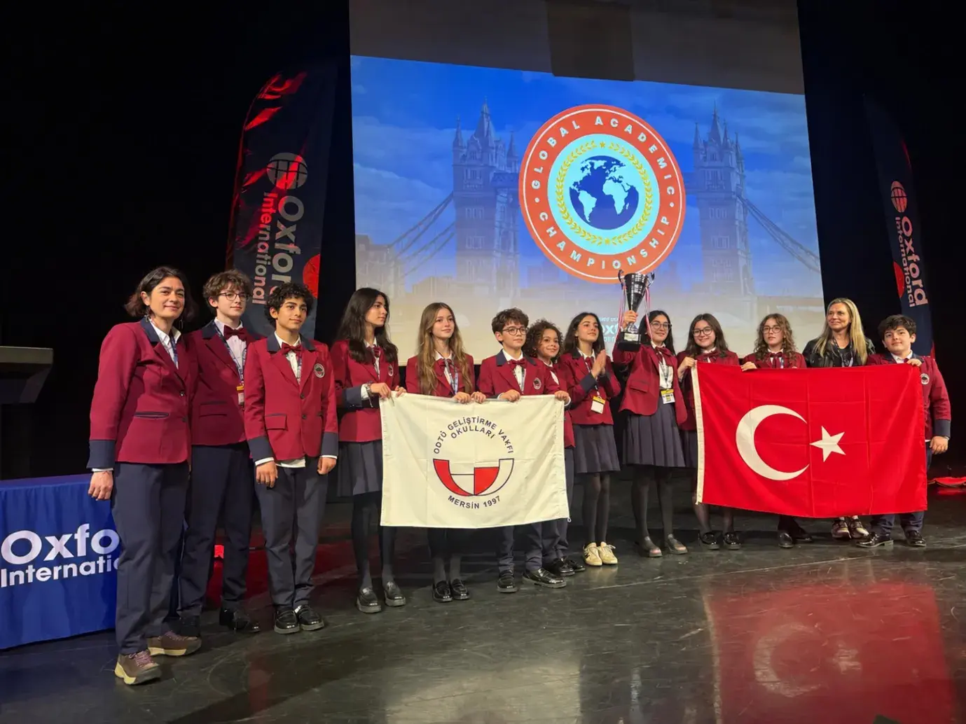 Global Academic Championship sahnesinde Türk bayrağıyla poz veren takım